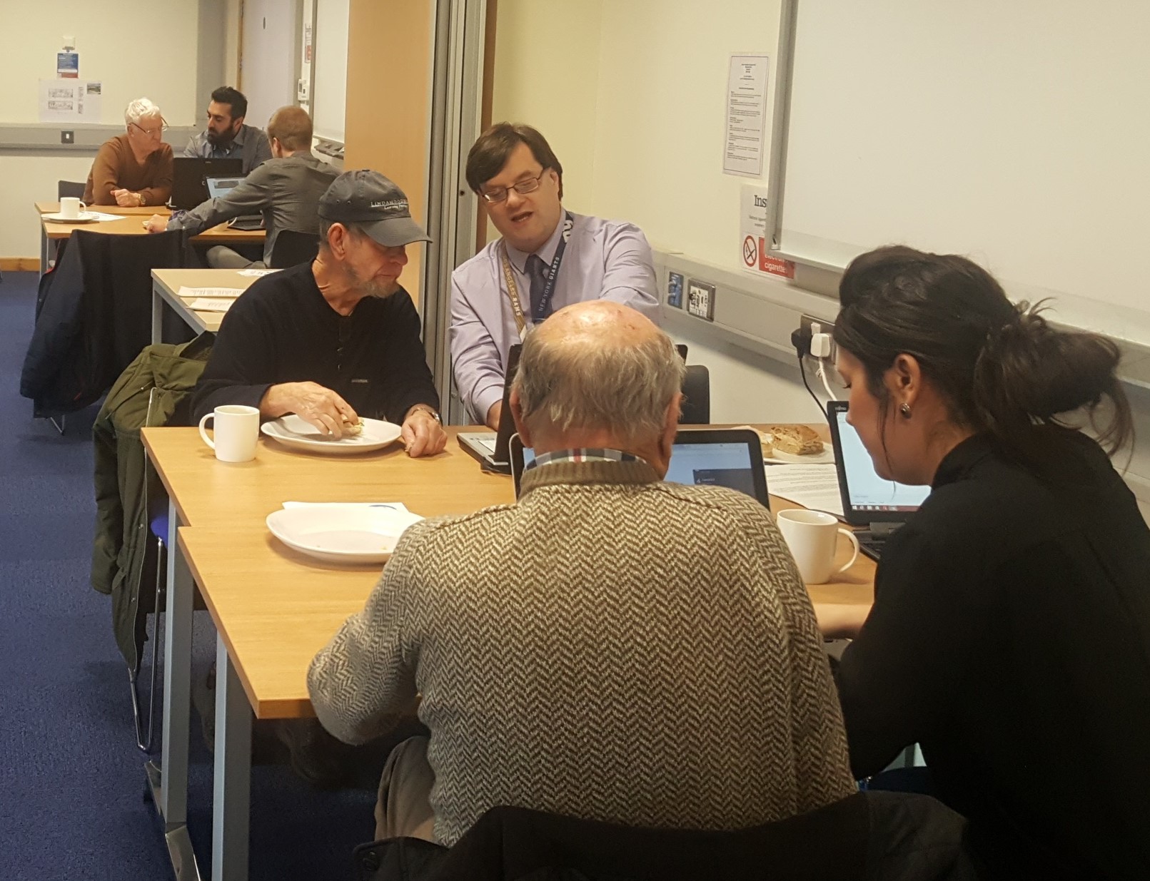 Volunteers with the EccyMensGroup at a table with laptops