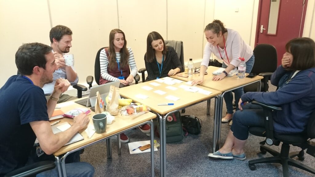 Six people in a working group sitting around a table in discussion