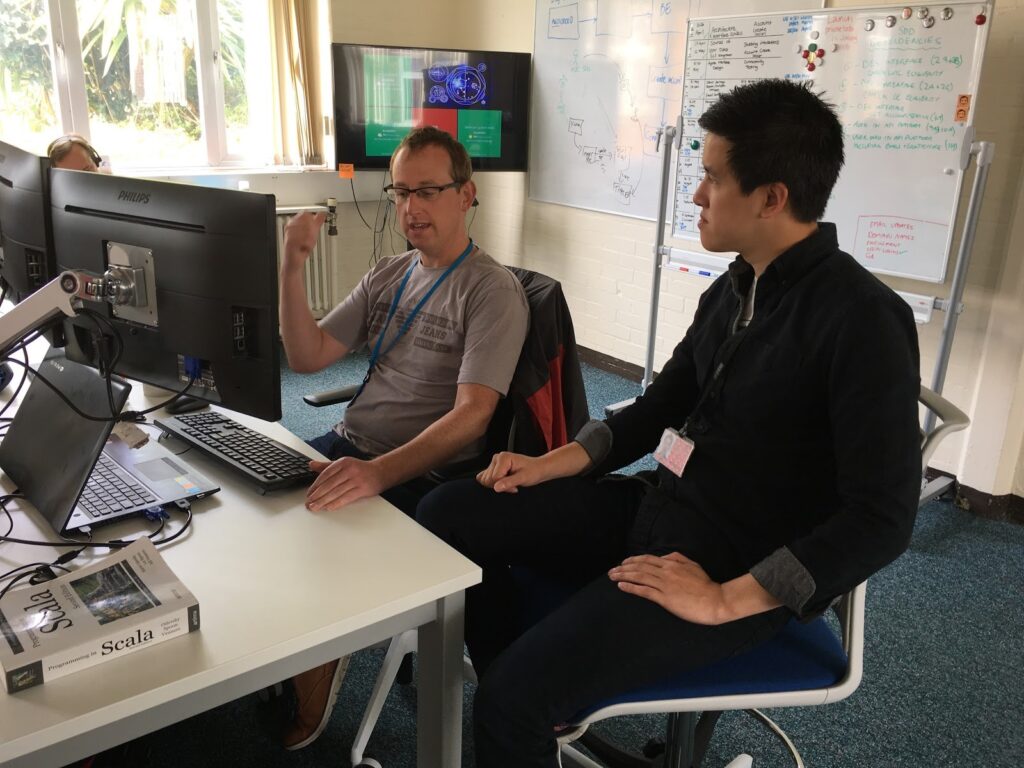 Two male testers pairing at a desk in our Digital Delivery Centre Worthing