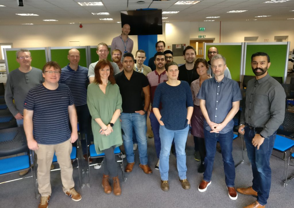 The Developer Hub team stand in an open plan office to pose for a team photo