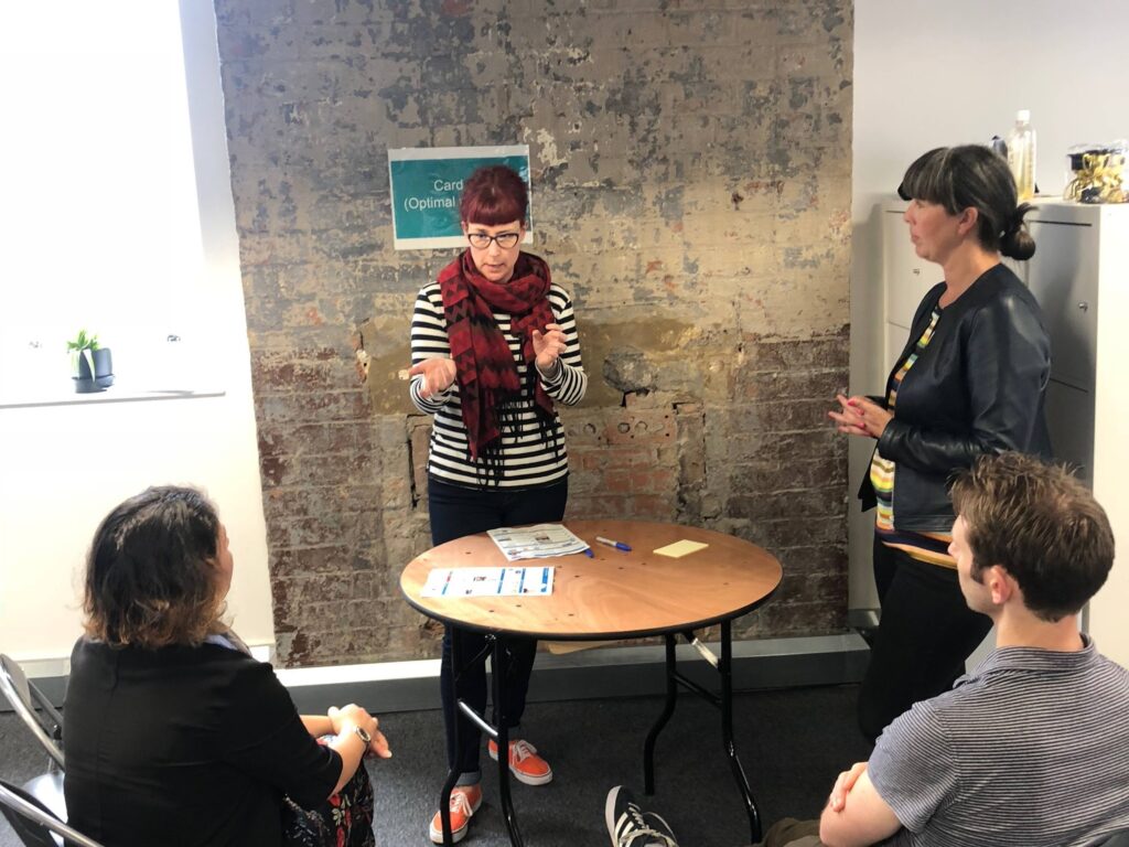 A small group of user researchers having a discussion around a small table