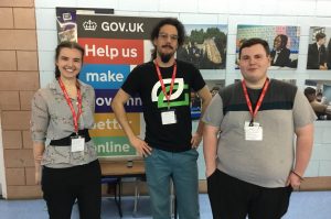 Jennifer McMillan, Louis Mannevy and Jack Witchell standing facing the camera in front of a gov.uk display board