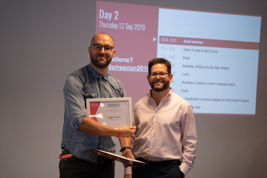 Image of two attendees, one presenting an award to the other