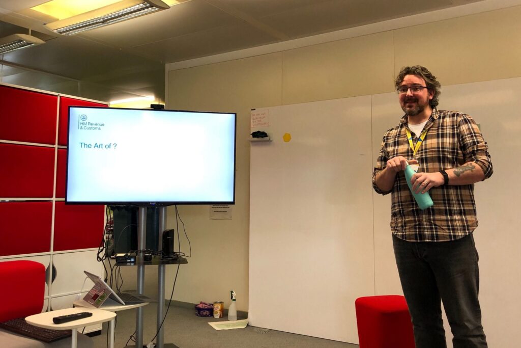 Ben Lovatt standing in front of a screen which says The Art of ?