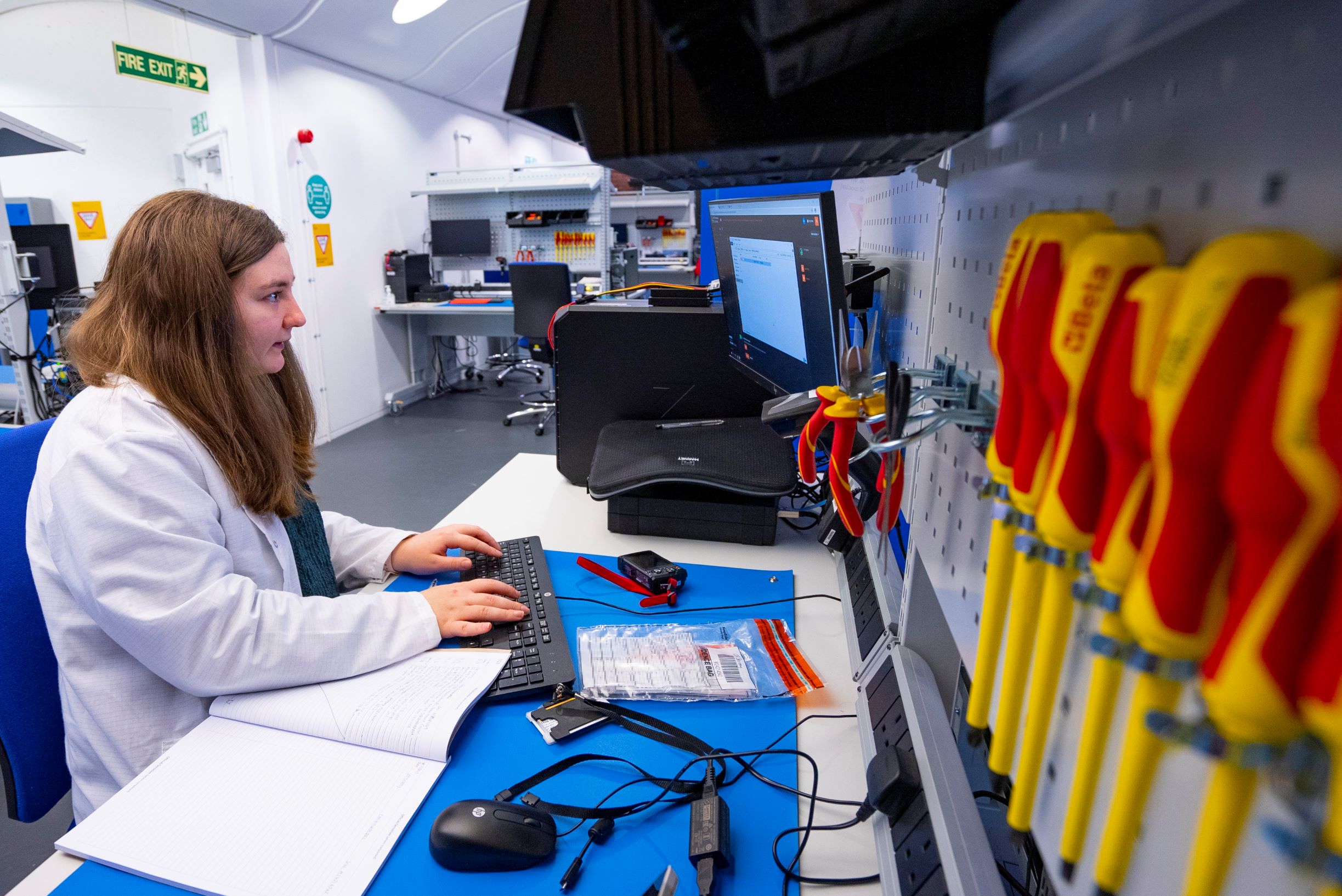 Image of a HMRC employee working at a desk in a digital forensics laboratory 