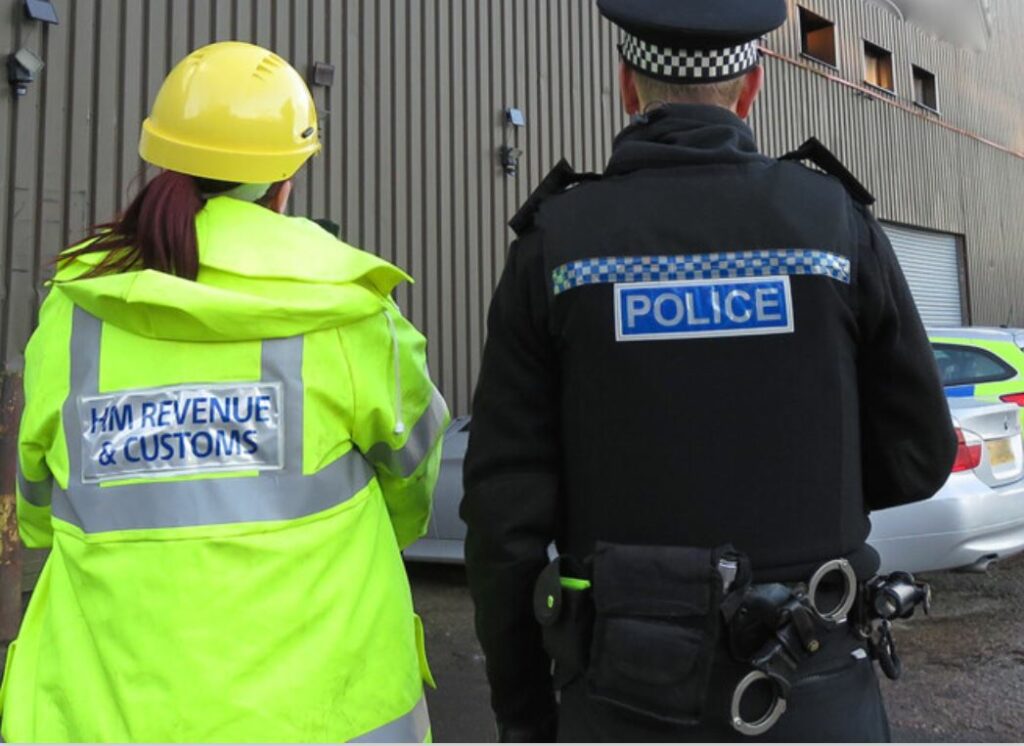  HMRC officer and policeman carrying out investigation 